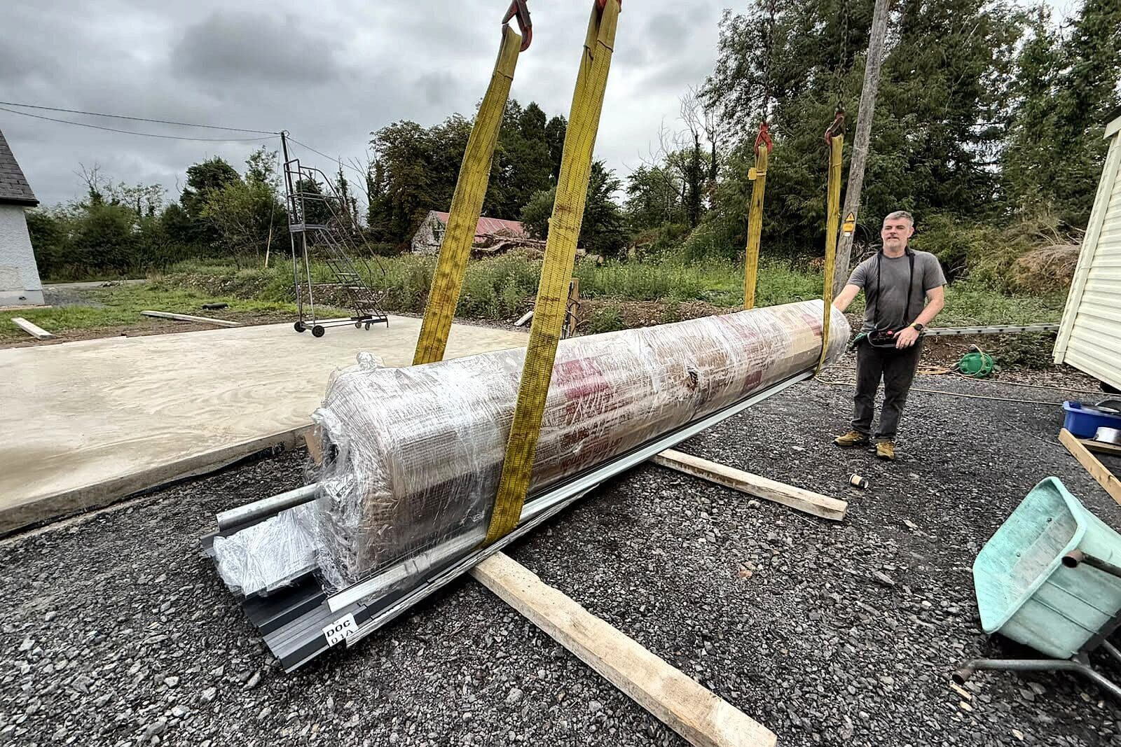 Steel sections being lowered beside a concrete base