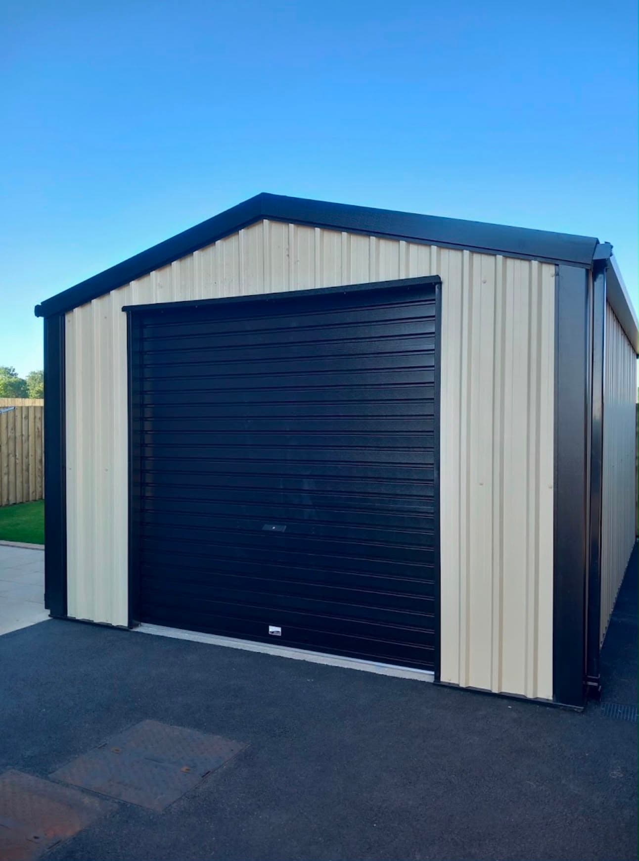 Cream single steel garage with black roller door