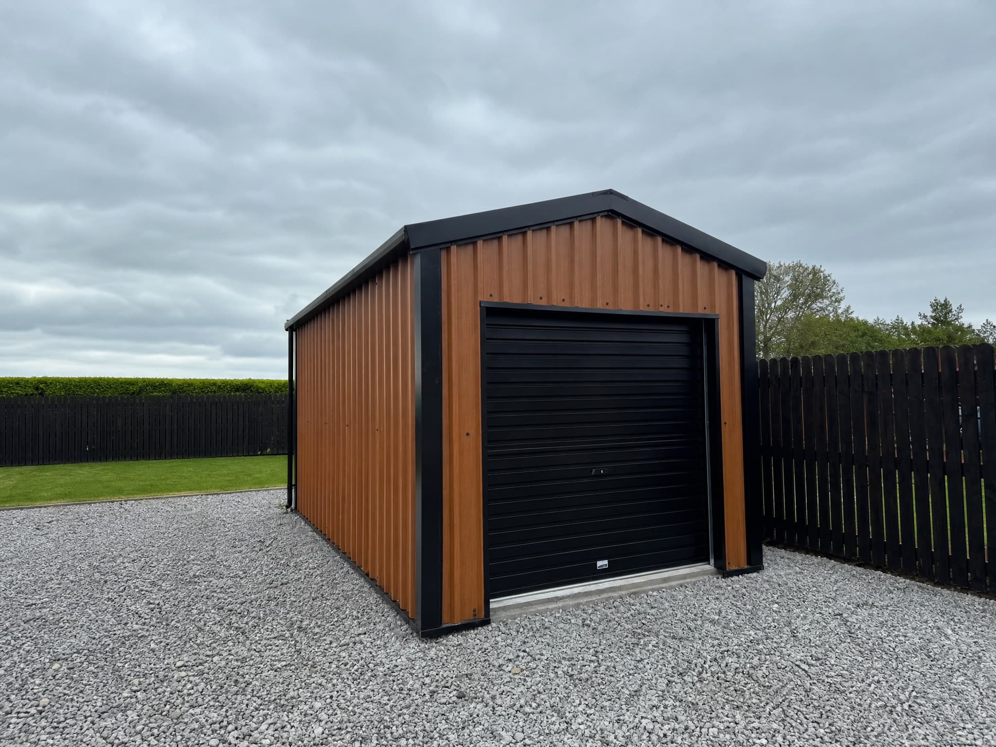 Compact woodgrain-effect steel shed with black roller door